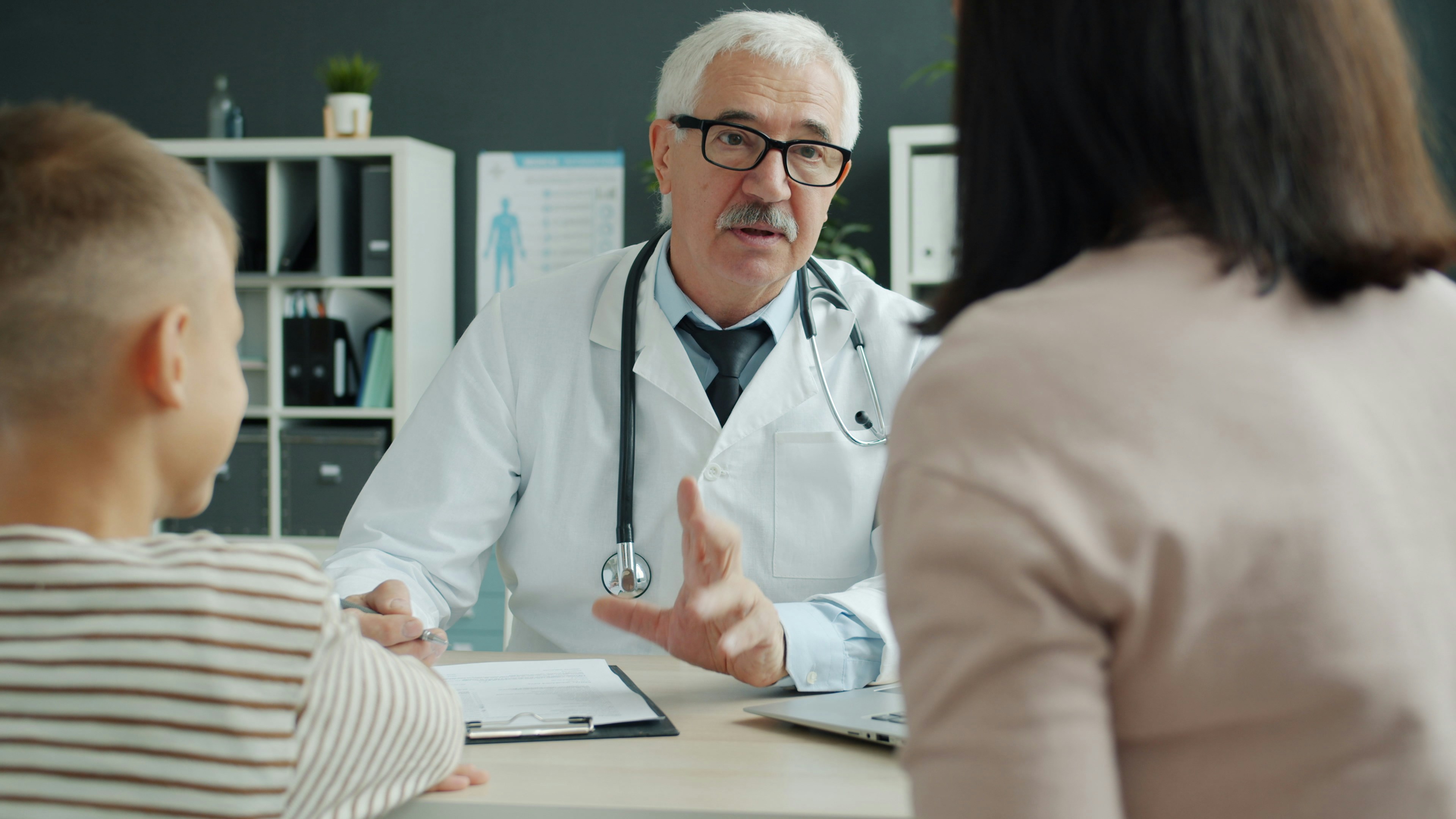 Parent and child discussing medical care with a doctor